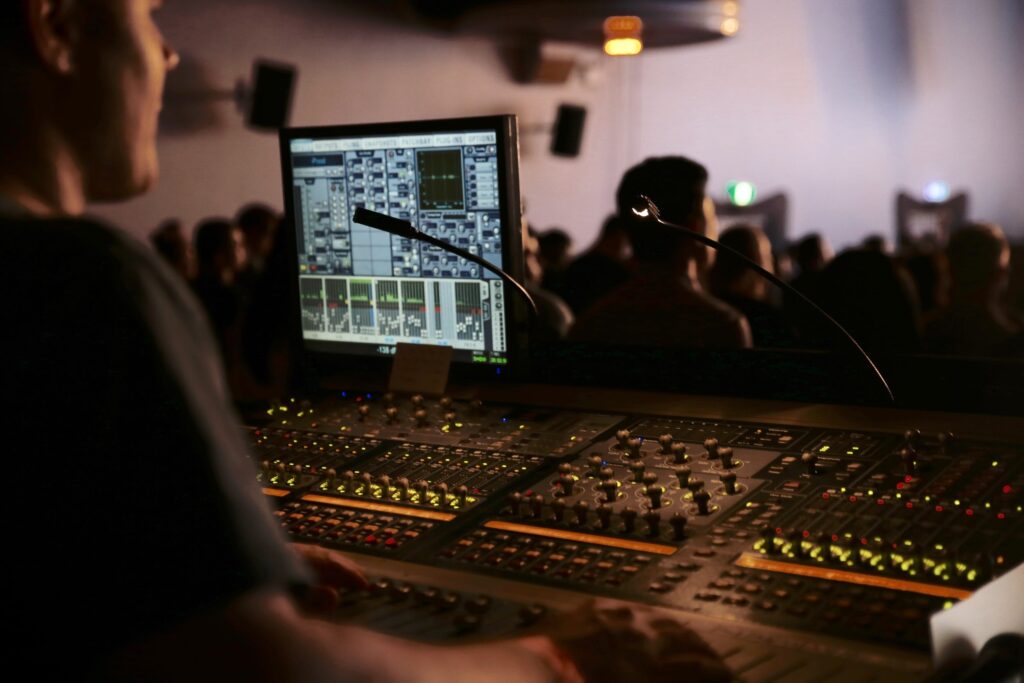 AV technician setting up commercial audio-visual equipment, including wall-mounted displays and cable management in a professional conference room.